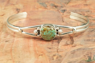 Genuine Number 8 Turquoise set in Sterling Silver. The Number 8 mine is located in Eureka County Nevada. Since 1976 there has been no Number 8 Turquoise mined. There is however, an existing stock pile that Mr. Dowell Ward, the last owner of the Number 8 mine, had stocked away for later sorting. The Turquoise is a collector's item--because once the reserve is gone there will be no more material released onto the market. The Gold Mining Company owns the claim to the Number 8 mine and it has been swallowed up by the gold mining operations. This is some of the last Number 8 Turquoise to be had and will be a great addition to your collection. Created by Navajo Artist Lucy Valencia. Signed L. J. by the artist..